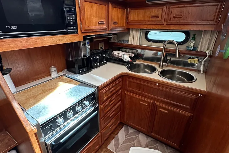 Slide: The Image of 1988 Carver 38 Aft Cabin kitchen with wood cabinetry, dual sinks, and modern appliances. - 18