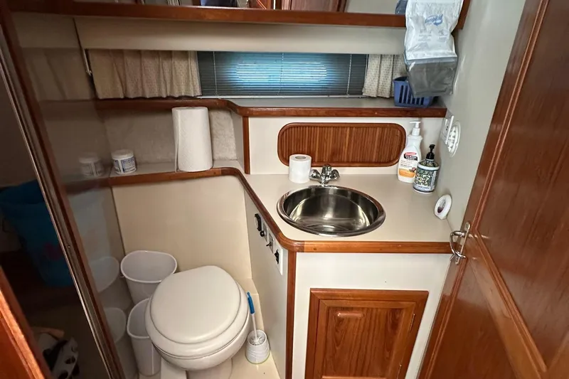 Slide: The Image of 1988 Carver 38 Aft Cabin bathroom with sink, toilet, and wooden accents. - 19