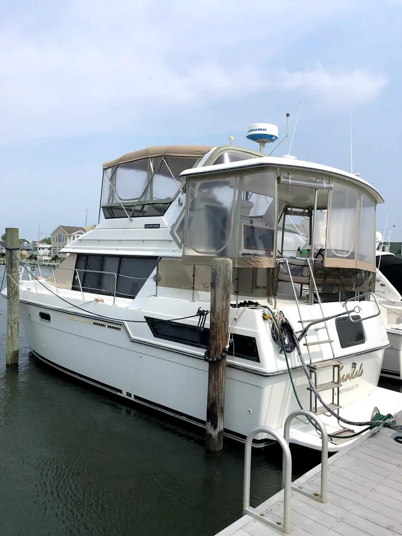 Slide: The Image of 1988 Carver 38 Aft Cabin yacht docked at marina under clear sky. - 2