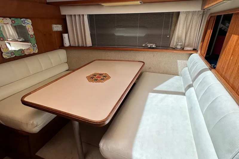 Slide: The Image of 1988 Carver 38 Aft Cabin interior dining area with cushioned seating and decorative table. - 21