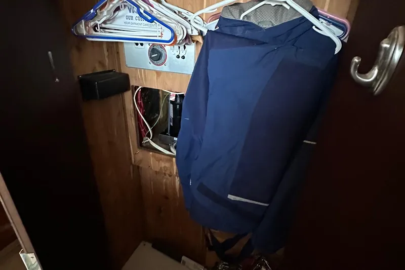 Slide: The Image of Closet interior of 1988 Carver 38 Aft Cabin with hanging clothes and exposed wiring. - 34
