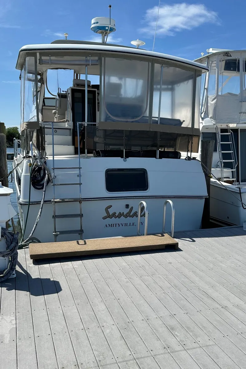Slide: The Image of 1988 Carver 38 Aft Cabin yacht docked, featuring a spacious aft deck and ladder access. - 6
