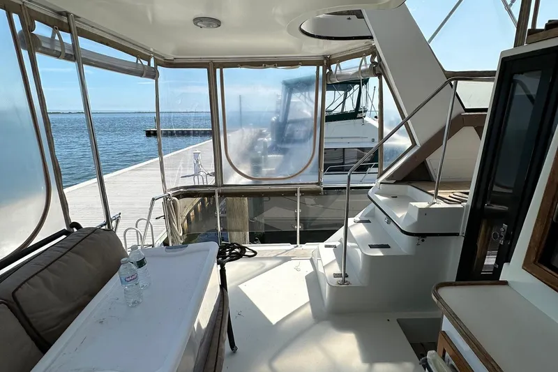 Slide: The Image of 1988 Carver 38 Aft Cabin yacht interior with dockside view and seating area. - 7