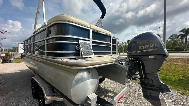 Slide: The Image of 2012 Xcursion X21C pontoon boat with Yamaha outboard motor, parked on a trailer. - 6
