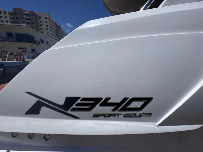 Slide: The Image of 2024 NX Boats 340 Sport Coupe logo on sleek white surface. - 10