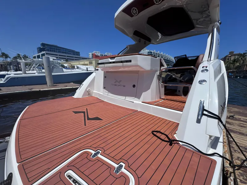 Slide: The Image of 2024 NX Boats 340 Sport Coupe with teak deck at marina. - 12