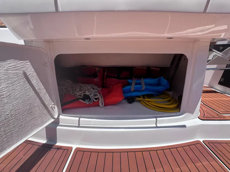 Slide: The Image of Storage compartment on 2024 NX Boats 340 Sport Coupe with life jackets and ropes. - 16