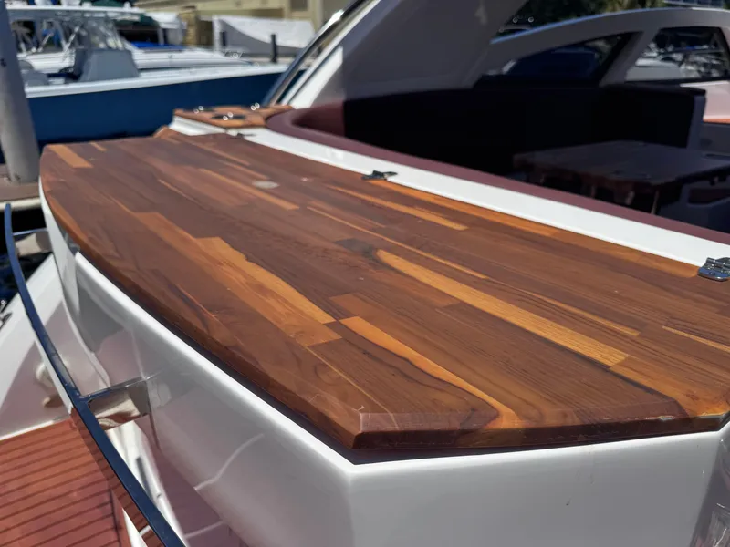 Slide: The Image of 2024 NX Boats 340 Sport Coupe with sleek wooden deck detail. - 17
