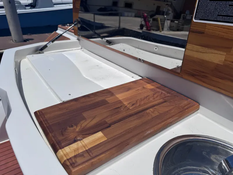 Slide: The Image of 2024 NX Boats 340 Sport Coupe deck with wooden panel and stainless steel sink. - 18