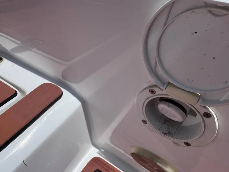 Slide: The Image of 2024 NX Boats 340 Sport Coupe deck detail with fuel cap and wooden accents. - 23