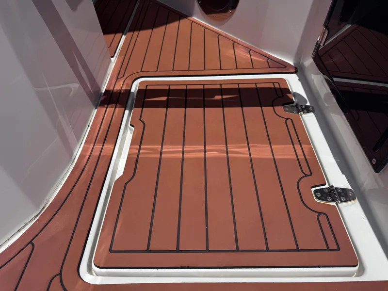 Slide: The Image of 2024 NX Boats 340 Sport Coupe deck with wood-like finish and hatch. - 24