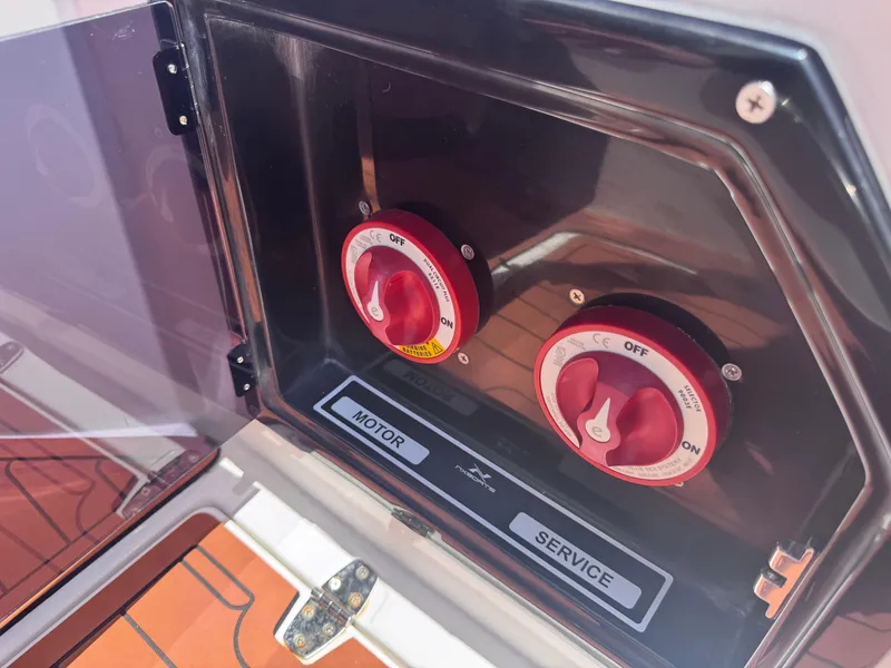 Slide: The Image of Battery switches on a 2024 NX Boats 340 Sport Coupe, labeled "Motor" and "Service." - 25