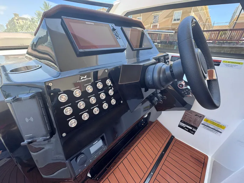Slide: The Image of 2024 NX Boats 340 Sport Coupe dashboard with modern controls and steering wheel. - 33
