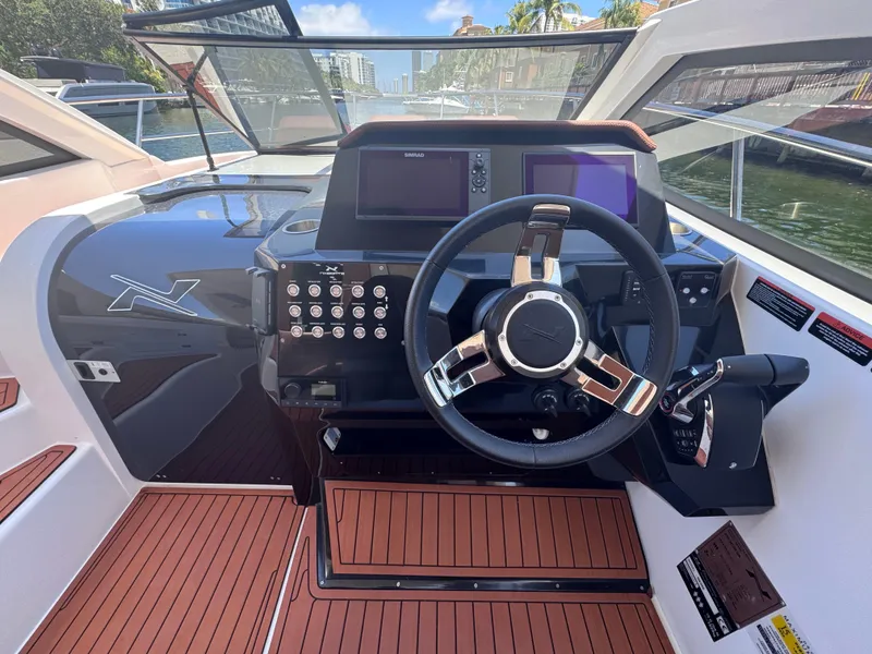 Slide: The Image of 2024 NX Boats 340 Sport Coupe dashboard with modern steering and navigation controls. - 34