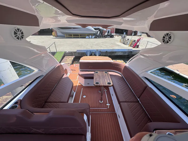 Slide: The Image of 2024 NX Boats 340 Sport Coupe interior with luxurious seating and wooden deck. - 41