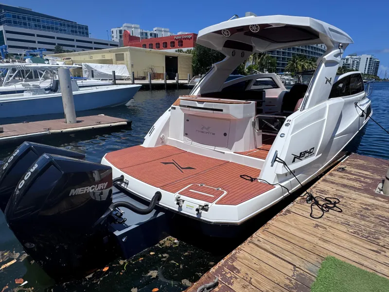 Slide: The Image of 2024 NX Boats 340 Sport Coupe docked, showcasing sleek design and powerful Mercury engine. - 5