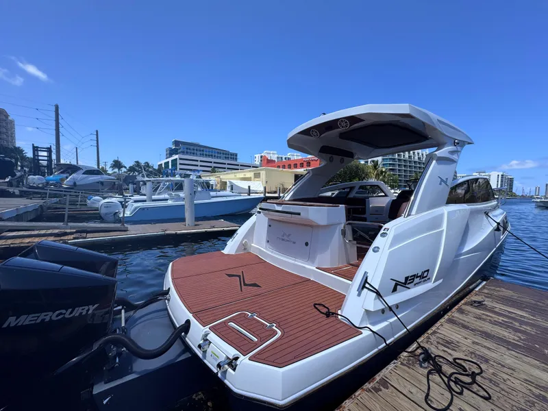 Slide: The Image of 2024 NX Boats 340 Sport Coupe docked at marina, showcasing sleek design and Mercury engine. - 7