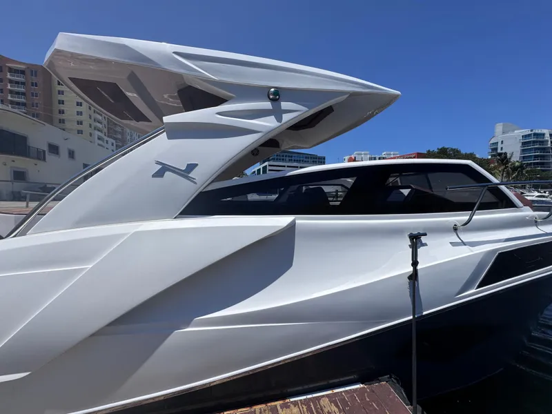 Slide: The Image of 2024 NX Boats 340 Sport Coupe docked, showcasing sleek design and modern architecture. - 8