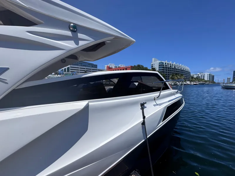 Slide: The Image of 2024 NX Boats 340 Sport Coupe docked in a marina under clear blue skies. - 9