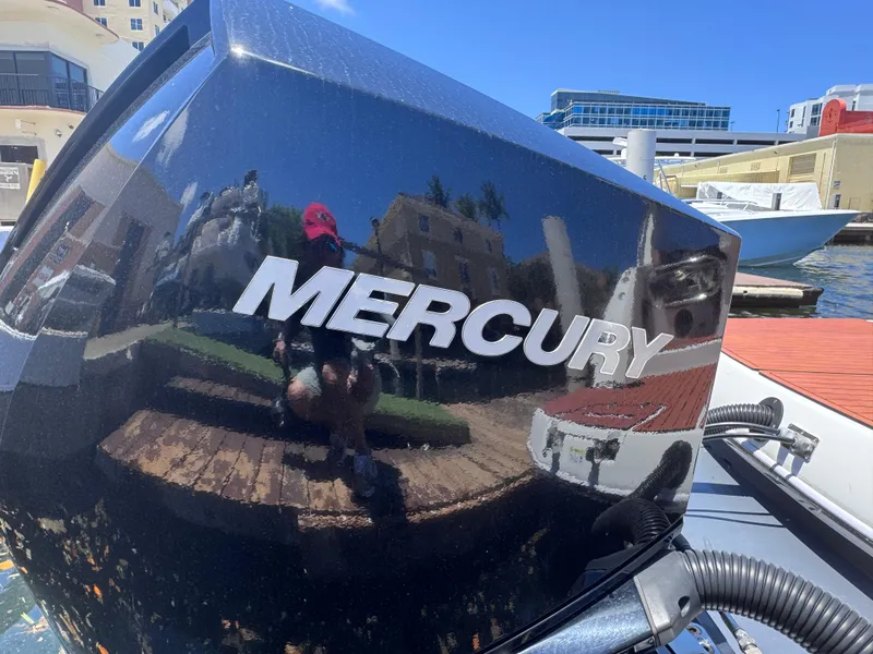 Slide: The Image of Mercury engine on 2024 NX Boats 340 Sport Coupe, docked in a marina. - 99