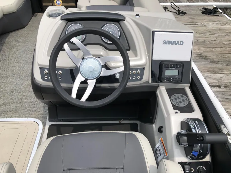 Slide: The Image of 2024 Barletta Cabrio 22UC boat dashboard with steering wheel and Simrad display. - 7