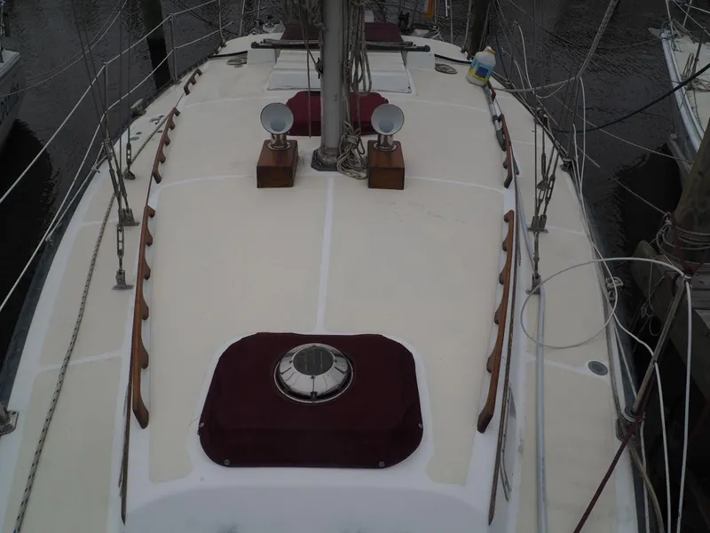 Slide: The Image of 1984 Endeavour 33 sailboat deck with maroon accents and wooden handrails. - 10