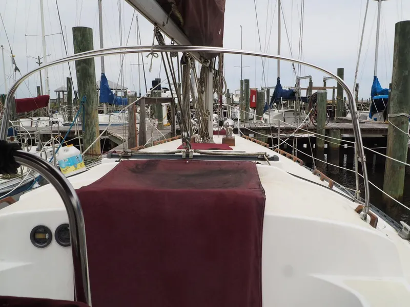 Slide: The Image of 1984 Endeavour 33 sailboat docked at marina, featuring maroon covers and visible rigging. - 11