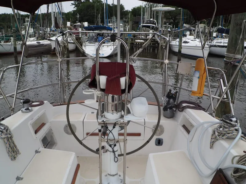 Slide: The Image of Cockpit of 1984 Endeavour 33 sailboat docked at marina, featuring steering wheel and seating. - 14