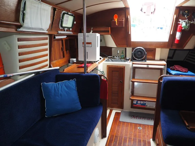 Slide: The Image of Interior of 1984 Endeavour 33 sailboat with blue seating and wooden accents. - 15