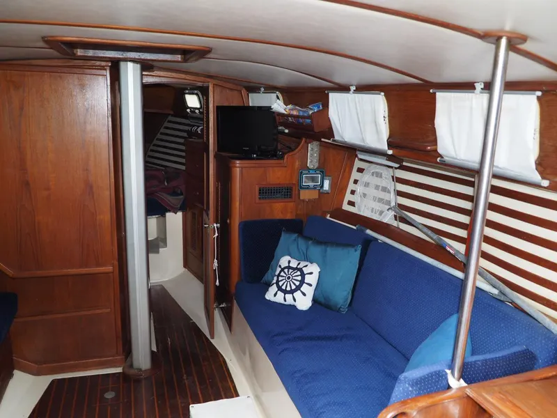 Slide: The Image of Interior of 1984 Endeavour 33 sailboat with blue seating and wooden finishes. - 18