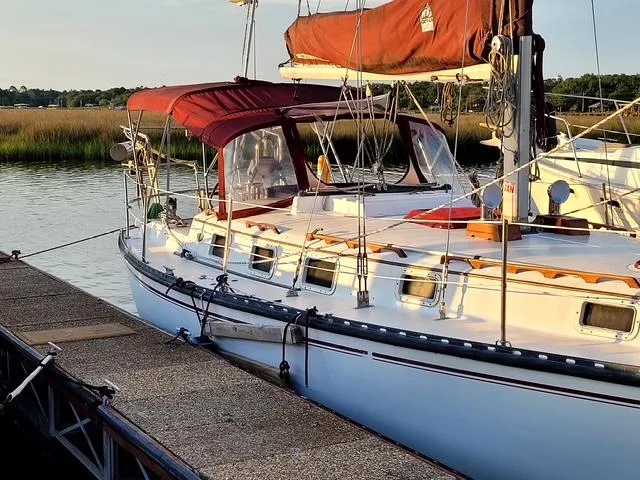 Slide: The Image of 1984 Endeavour 33 sailboat docked by a serene riverside with lush greenery. - 2