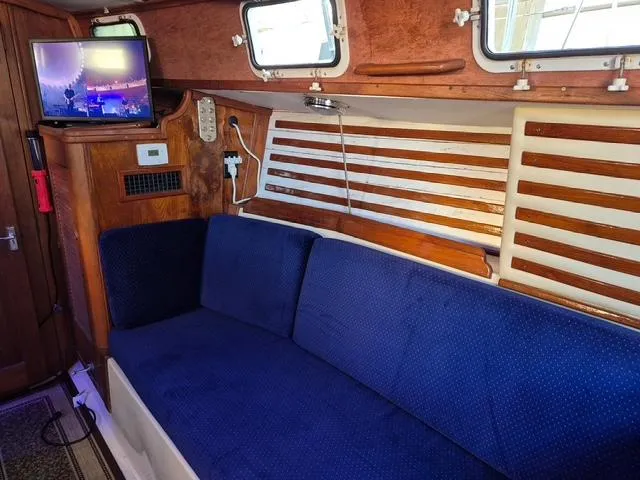 Slide: The Image of Interior of 1984 Endeavour 33 sailboat with blue seating and mounted TV. - 20