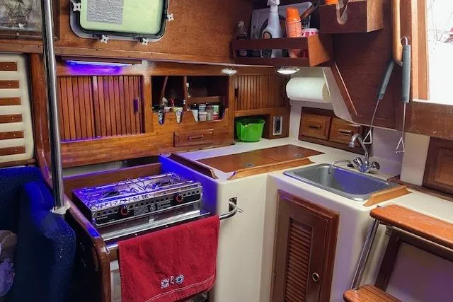 Slide: The Image of 1984 Endeavour 33 yacht kitchen with stove, sink, and wooden cabinetry. - 23