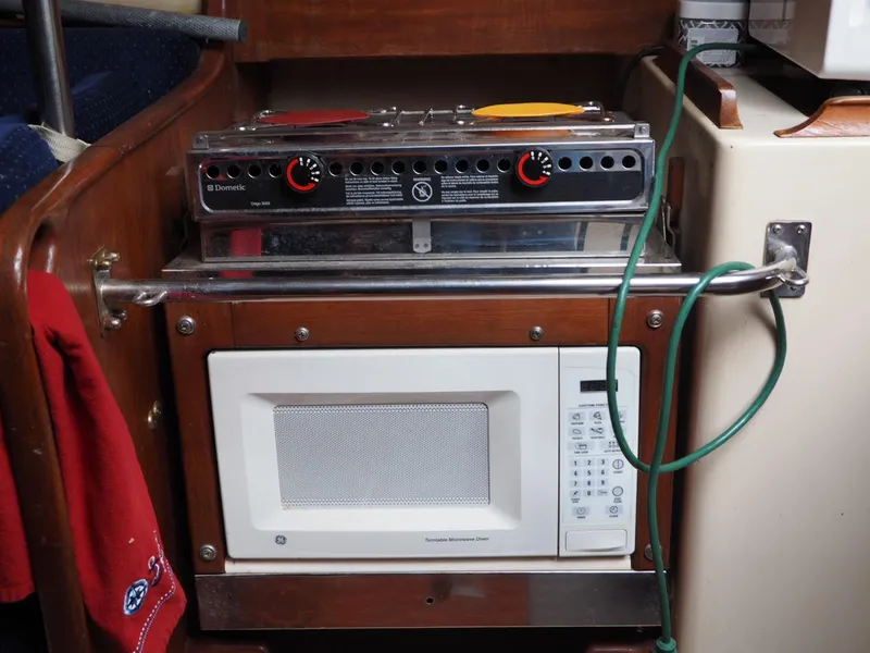 Slide: The Image of Compact kitchen setup in 1984 Endeavour 33 sailboat with stove and microwave. - 24