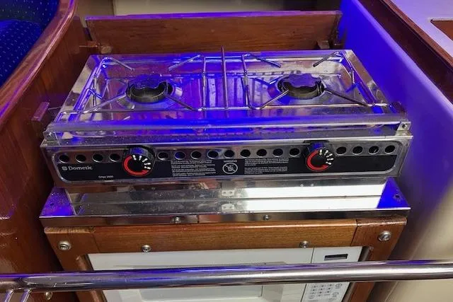 Slide: The Image of Stove in 1984 Endeavour 33 yacht kitchen, featuring dual burners and wooden cabinetry. - 25