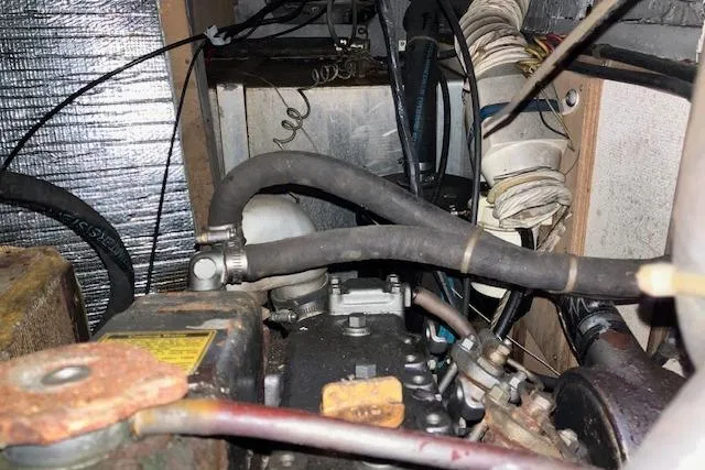 Slide: The Image of Engine compartment of a 1984 Endeavour 33 sailboat, showing hoses and mechanical components. - 37