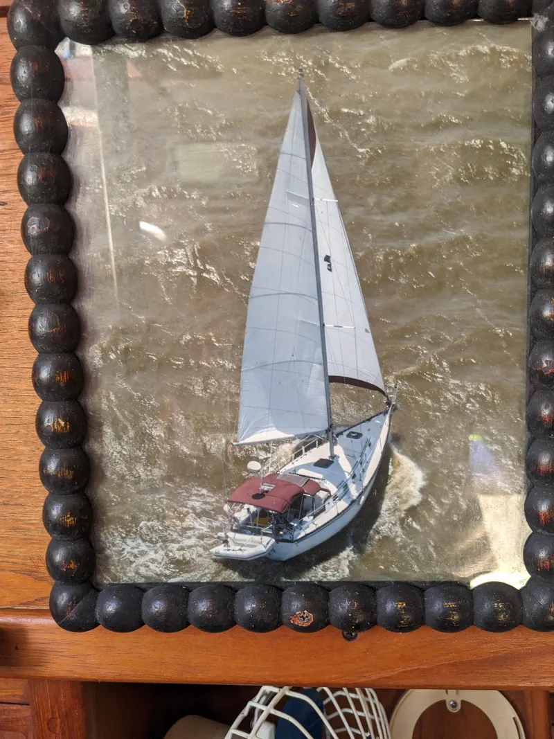 Slide: The Image of 1984 Endeavour 33 sailboat navigating choppy waters, framed with decorative beads. - 38