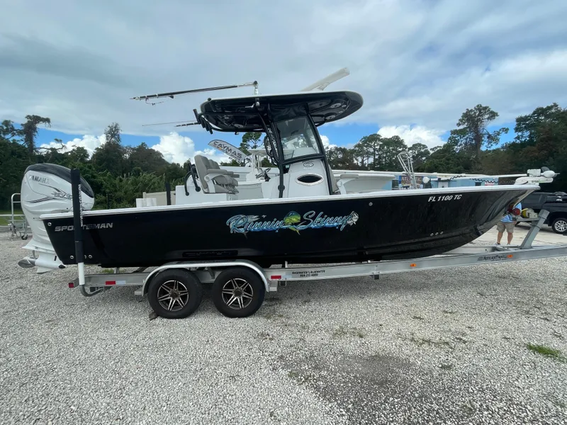 Slide: The Image of 2022 Sportsman Masters 267OE Bay Boat on trailer, black hull, parked outdoors. - 5