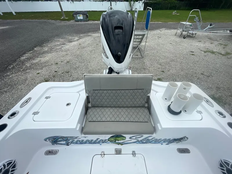 Slide: The Image of 2022 Sportsman Masters 267OE Bay Boat with cushioned seating and motor, parked on gravel. - 8