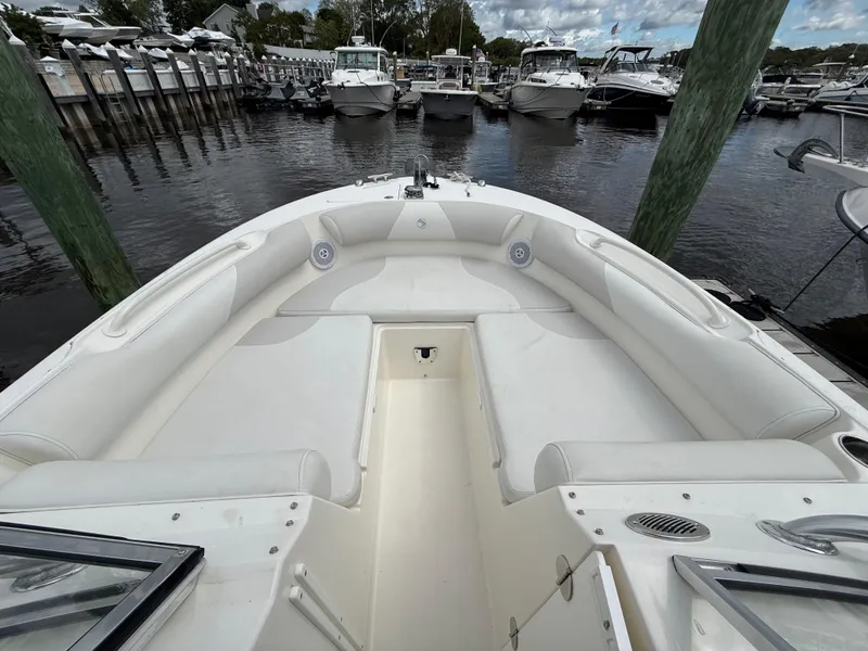 Slide: The Image of 2012 Edgewater 245 CX boat with spacious seating, docked at a marina. - 10