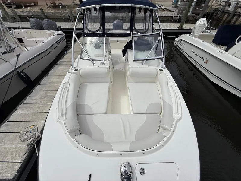 Slide: The Image of 2012 Edgewater 245 CX boat docked, featuring spacious seating and sleek design. - 11
