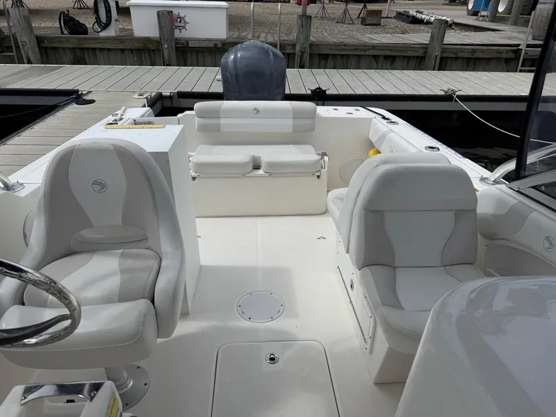 Slide: The Image of Interior of a 2012 Edgewater 245 CX boat with white seating and steering wheel. - 4
