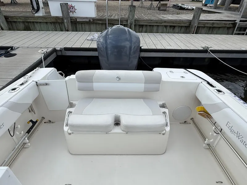 Slide: The Image of 2012 Edgewater 245 CX boat interior with seating and outboard motor at dock. - 5