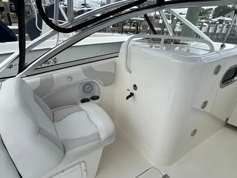 Slide: The Image of 2012 Edgewater 245 CX boat interior with white seating and control panel. - 8