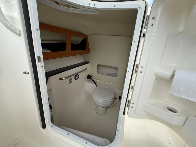 Slide: The Image of 2012 Edgewater 245 CX boat interior bathroom with toilet and storage. - 9