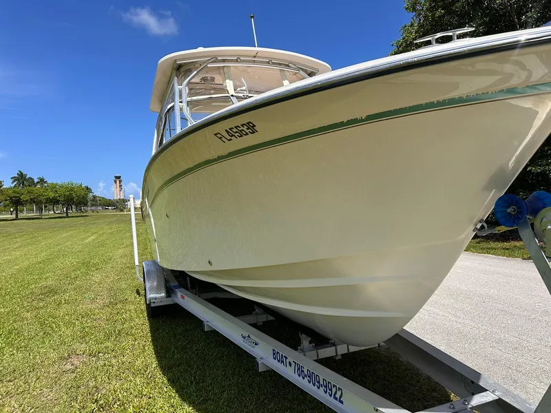 Slide: The Image of 2011 Grady-White Freedom 275 boat on trailer, parked on grass under clear blue sky. - 11