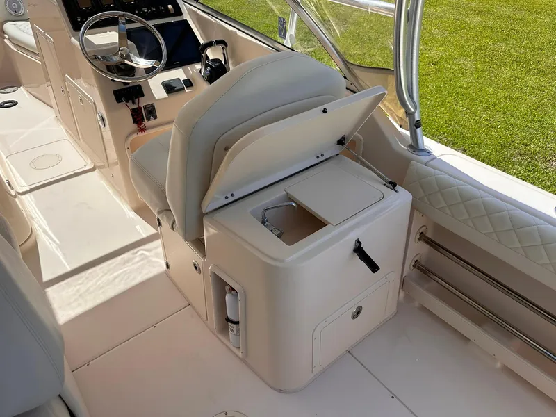 Slide: The Image of 2011 Grady-White Freedom 275 boat interior with helm seat and storage compartment. - 19