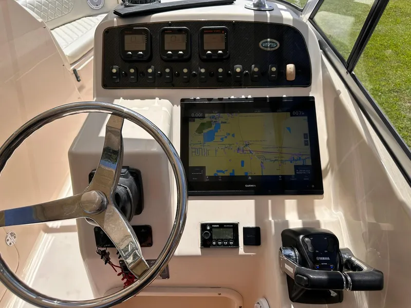 Slide: The Image of 2011 Grady-White Freedom 275 boat dashboard with steering wheel and navigation system. - 22