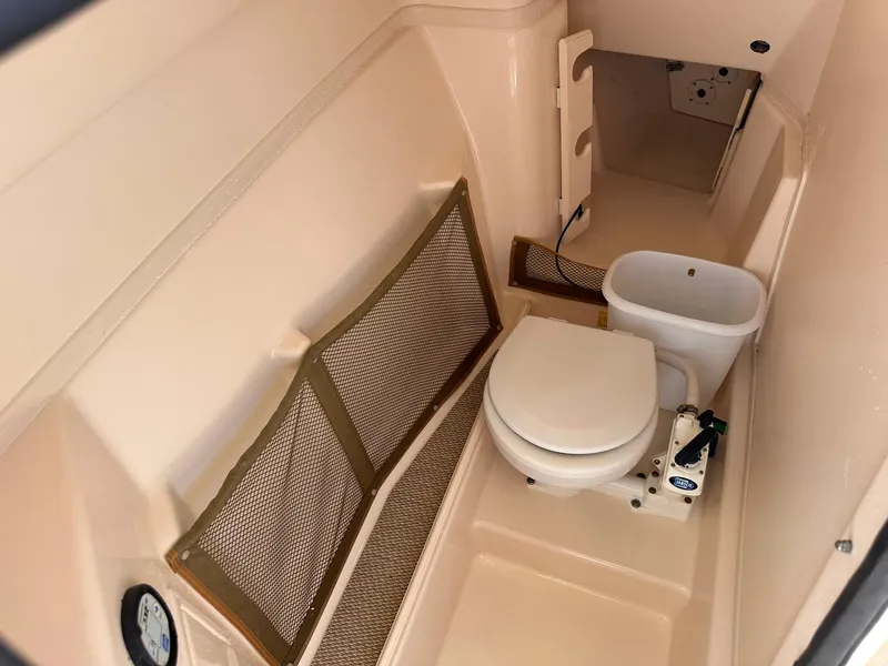 Slide: The Image of 2011 Grady-White Freedom 275 boat interior with toilet and storage netting. - 33