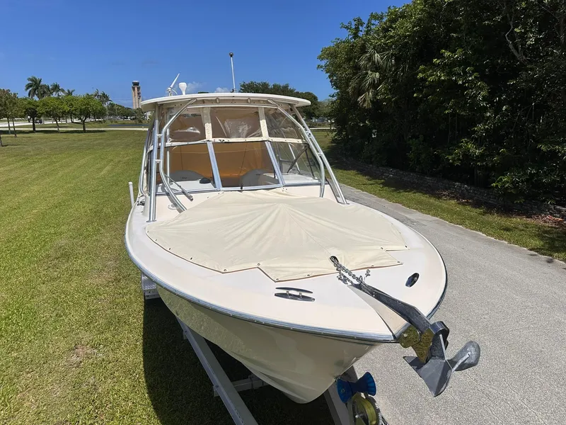 Slide: The Image of 2011 Grady-White Freedom 275 boat on trailer, parked on grass under clear blue sky. - 34